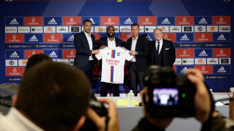 Alexandre Lacazette entouré de Bruno Cheyrou, Vincent Ponsot et Jean-Michel Aulas lors de sa présentation à l'OL