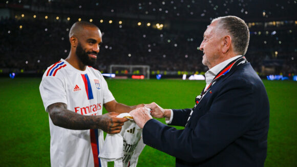 Alexandre Lacazette remettant un maillot collector à Jean-Michel Aulas