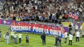 Les joueurs de l'OL posant avec la banderole des supporters lyonnais